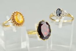 THREE GEMSTONE RINGS, to include a sapphire and diamond cluster ring, ring size P, an oval garnet