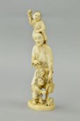 A LATE 19TH CENTURY JAPANESE IVORY OKIMONO, carved with a young boy holding a stick standing on a