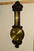 A 20TH CENTURY CARVED OAK ANEROID BAROMETER