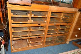 A GOLDEN OAK HABERDASHERY CABINET comprising of six glazed disappearing flaps (missing bottom left
