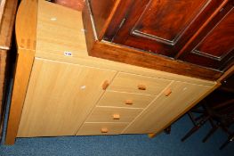 A LIGHT OAK FINISH SIDEBOARD with four drawers central to two cupboard doors, approximate width