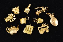 TEN MAINLY GOLD LOOSE CHARMS to include a windmill stamped 750, a vintage fire engine with 9ct
