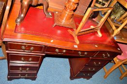 A REPRODUCTION MAHOGANY SERPENTINE PEDESTAL DESK with tooled leather inlay top and eight various