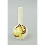 A SMALL MOORCROFT POTTERY BUD VASE, 'Leaves in the Wind' pattern on cream ground, paper label to