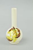 A SMALL MOORCROFT POTTERY BUD VASE, 'Leaves in the Wind' pattern on cream ground, paper label to