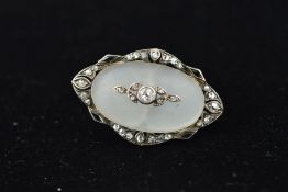 AN EARLY 20TH CENTURY DIAMOND AND QUARTZ OVAL BROOCH centering on an oval cabochon cut frosted