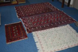 A 20TH CENTURY CAUCASION STYLE RUG, red ground with geometric detail, 184cm x 126cm, a matching