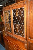 AN OAK LEAD GLAZED TWO DOOR BOOKCASE, an oak fire surround, an oak open bookcase, a coffee table,