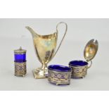 AN EARLY 20TH CENTURY CRUET SET AND A LATE VICTORIAN CREAM JUG, the cruet set with blue glass liners