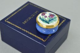 A BOXED MOORCROFT ENAMEL PILL BOX, decorated with Thistles