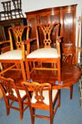 A REPRODUCTION MAHOGANY DINING SUITE comprising of an oval extending table with one additional leaf,