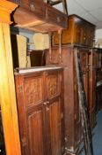 AN OAK LINENFOLD THREE PIECE BEDROOM SUITE comprising of a two door wardrobe, gentleman's wardrobe