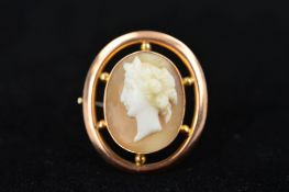 AN EARLY 20TH CENTURY 9CT GOLD CAMEO BROOCH, of oval outline, the shell carved to depict a lady in