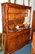 A PINE KITCHEN DRESSER, with two tier plate rack, six various drawers and triple cupboard, width