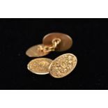 AN EDWARDIAN PAIR OF OVAL CUFFLINKS fully engraved in a foliate design, chain link connectors,