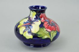 A MOORCROFT POTTERY SQUAT VASE, 'Hibiscus' pattern on blue ground, impressed and label to base,