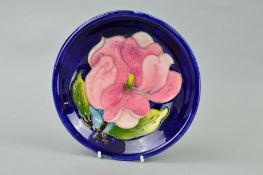 A MOORCROFT POTTERY SHALLOW BOWL, 'Magnolia' pattern on blue ground, impressed marks and painted
