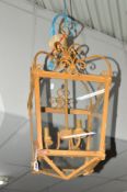 A WROUGHT IRON SQUARE TAPERING LANTERN with a scrolled top and electrical wiring