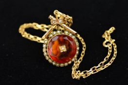AN EARLY 20TH CENTURY GOLD ORANGE PASTE AND SPLIT PEARL PENDANT, designed as a circular orange paste