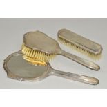 AN ELIZABETH II SILVER BACKED THREE PIECE DRESSING TABLE SET, comprising hand mirror and two