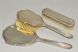 AN ELIZABETH II SILVER BACKED THREE PIECE DRESSING TABLE SET, comprising hand mirror and two