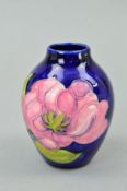 A SMALL MOORCROFT POTTERY VASE, 'Magnolia' pattern on blue ground, impressed and painted marks to