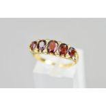 A LATE VICTORIAN 18CT GOLD FIVE STONE GARNET RING, designed as five graduated oval garnets with