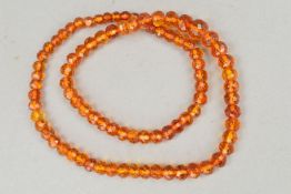 A MODIFIED AMBER NECKLACE, designed as graduated, faceted modified amber beads measuring 7mm to 9mm,