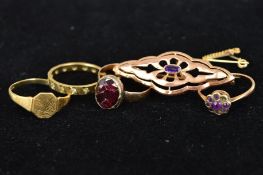 FOUR GOLD RINGS AND A BROOCH to include a late 19th Century oval garnet ring (crack to garnet), ring