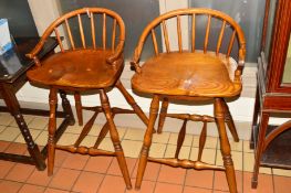 A PAIR OF GOLDEN OAK SWIVEL BAR STOOLS with a shaped spindled back