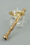 A 9CT GOLD RING AND AN EDWARDIAN RETRACTABLE TOOTHPICK, the ring designed as a circular cubic