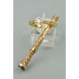 A 9CT GOLD RING AND AN EDWARDIAN RETRACTABLE TOOTHPICK, the ring designed as a circular cubic