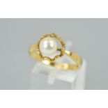 A 9CT GOLD CULTURED PEARL RING designed as a single cultured pearl a top a horizontal within an open