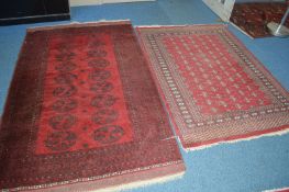 A 20TH CENTURY CAUCASION STYLE RED AND BLACK RUG, with multi strap border, approximate size 228cm