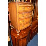 A REPRODUCTION WALNUT CHEST OF FOUR LONG DRAWERS (distressed), a mahogany serpentine two door