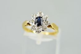 AN 18CT GOLD SAPPHIRE AND DIAMOND CLUSTER RING, designed as an oval sapphire within an illusion