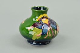 A SMALL MOORCROFT POTTERY SQUAT VASE, 'Columbine' pattern on green ground, impressed marks to base
