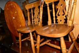 AN OAK OVAL TILT TOP OCCASIONAL TABLE, together with two pine kitchen chairs (3)