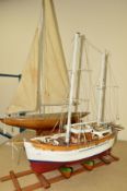A WOODEN SCRATCH BUILT MODEL OF A FISHING VESSEL painted red and white on a wooden stand,
