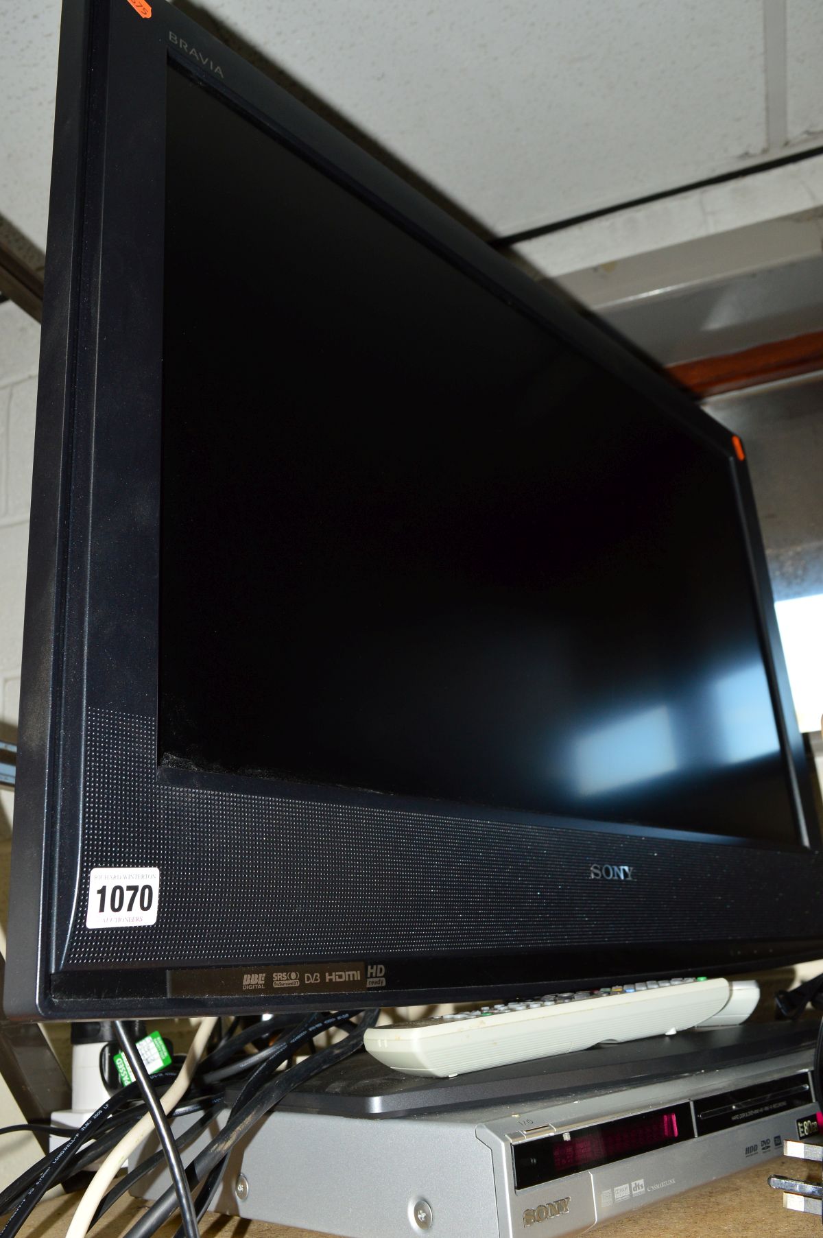 A SONY 32' LCD TV with a Sony hard drive recorder, two tier glass TV stand (positioned opposite to