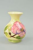 A SMALL MOORCROFT POTTERY VASE, 'Magnolia' pattern on a cream ground, impressed marks to base,