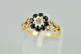 A 9CT GOLD SAPPHIRE AND DIAMOND RING, the central single cut diamond in an illusion setting within a