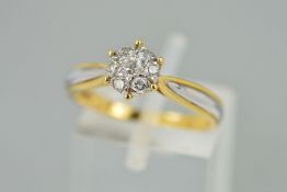 A DIAMOND CLUSTER RING designed as a central brilliant cut diamond surrounded by six further