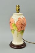 A MOORCROFT POTTERY TABLE LAMP, Hibiscus pattern on cream ground, on wooden plinth, approximate