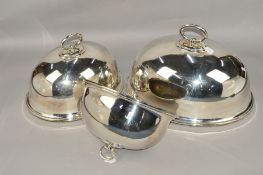 A GRADUATED SET OF THREE DOMED OVAL PLATE COVERS, each with central loop handle and a hanging