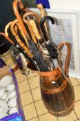 A COOPERED COPPER JUG, with a quantity of walking sticks and umbrellas