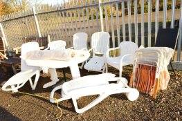 A WHITE PLASTIC GARDEN TABLE with two sun loungers, two reclining chairs and two other chairs, a