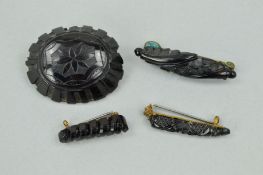 FOUR LATE VICTORIAN JET BROOCHES to include one of oval outline and three elongated outlines, all