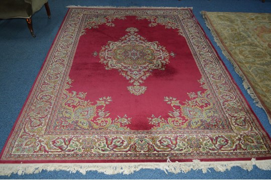 A WOOLLEN CARPET SQUARE, red ground, foliate design with central medallion, approximate size 303cm x