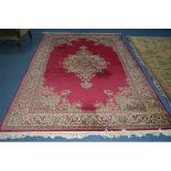 A WOOLLEN CARPET SQUARE, red ground, foliate design with central medallion, approximate size 303cm x